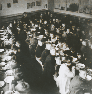 876780 Afbeelding van een grote groep kinderen die aan het eten is in een klaslokaal van de Piusschool (Oudegracht 33) ...